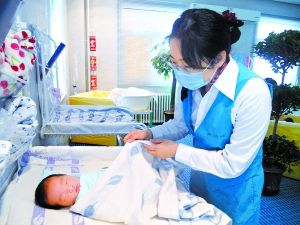 记者李环宇轻手轻脚地给孩子盖被子